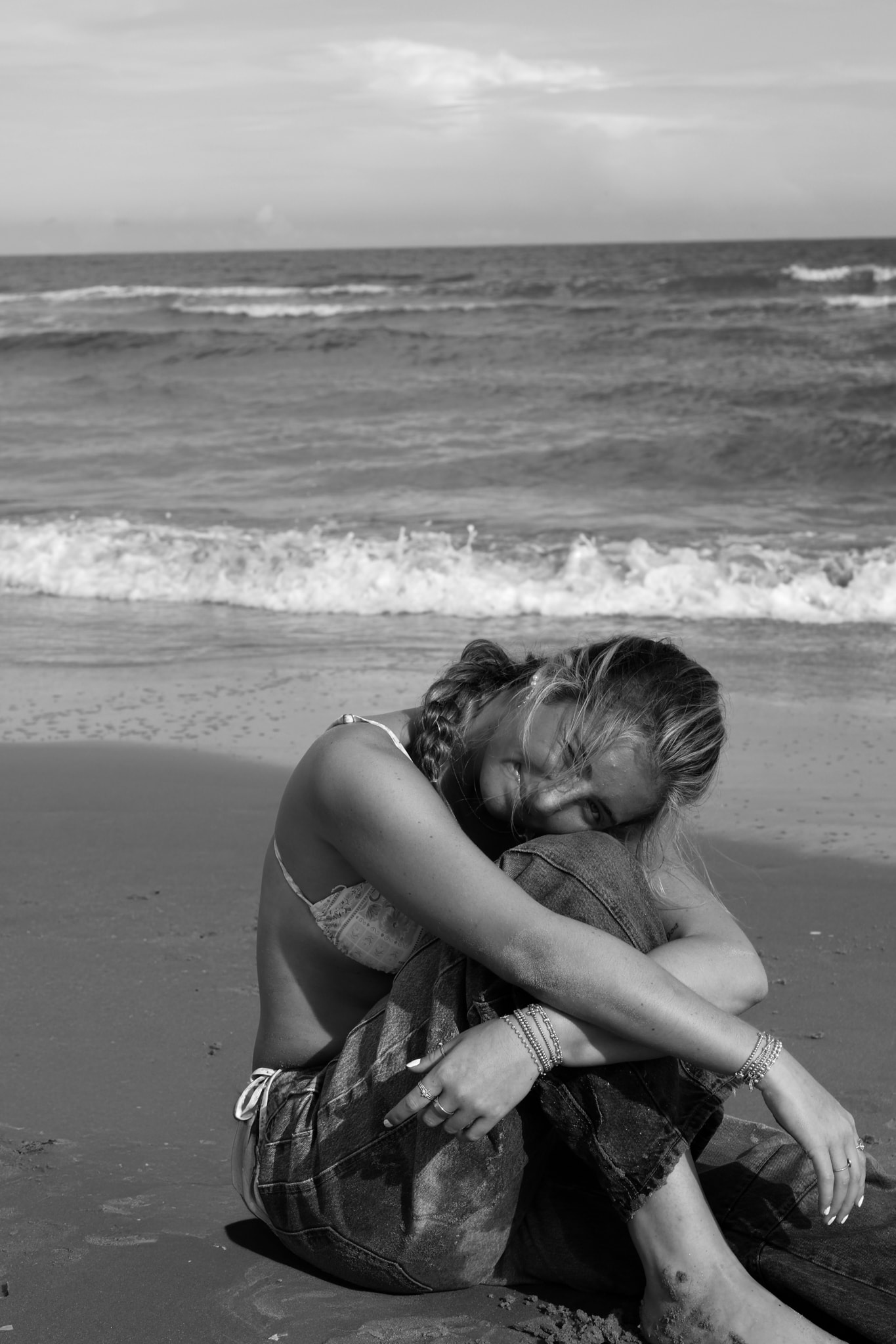Black and white, curled up on the sand, contemplative